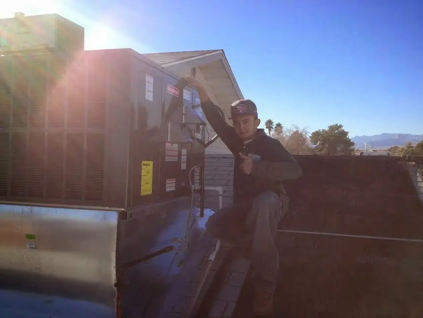 HVAC technician performing Boiler Repair on a rooftop unit in Washington